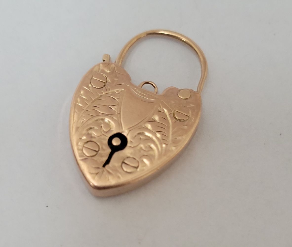 A 9CT GOLD LOVE HEART LOCK CHARM / PENDANT, decorated with engraved foliage deco&hellip;