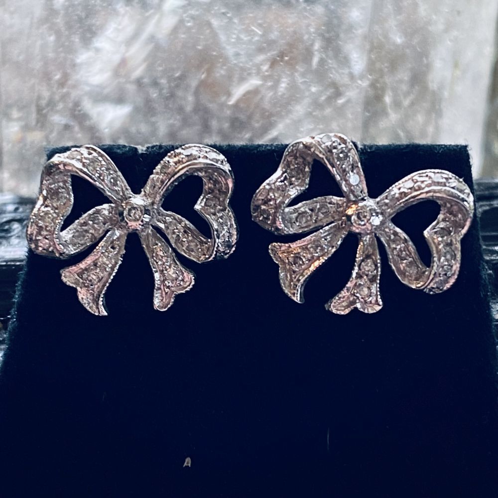 A CHARMING PAIR OF 9CT WHITE GOLD 1920S VINTAGE DIAMOND BOW EARRINGS. UNE CHARMA&hellip;