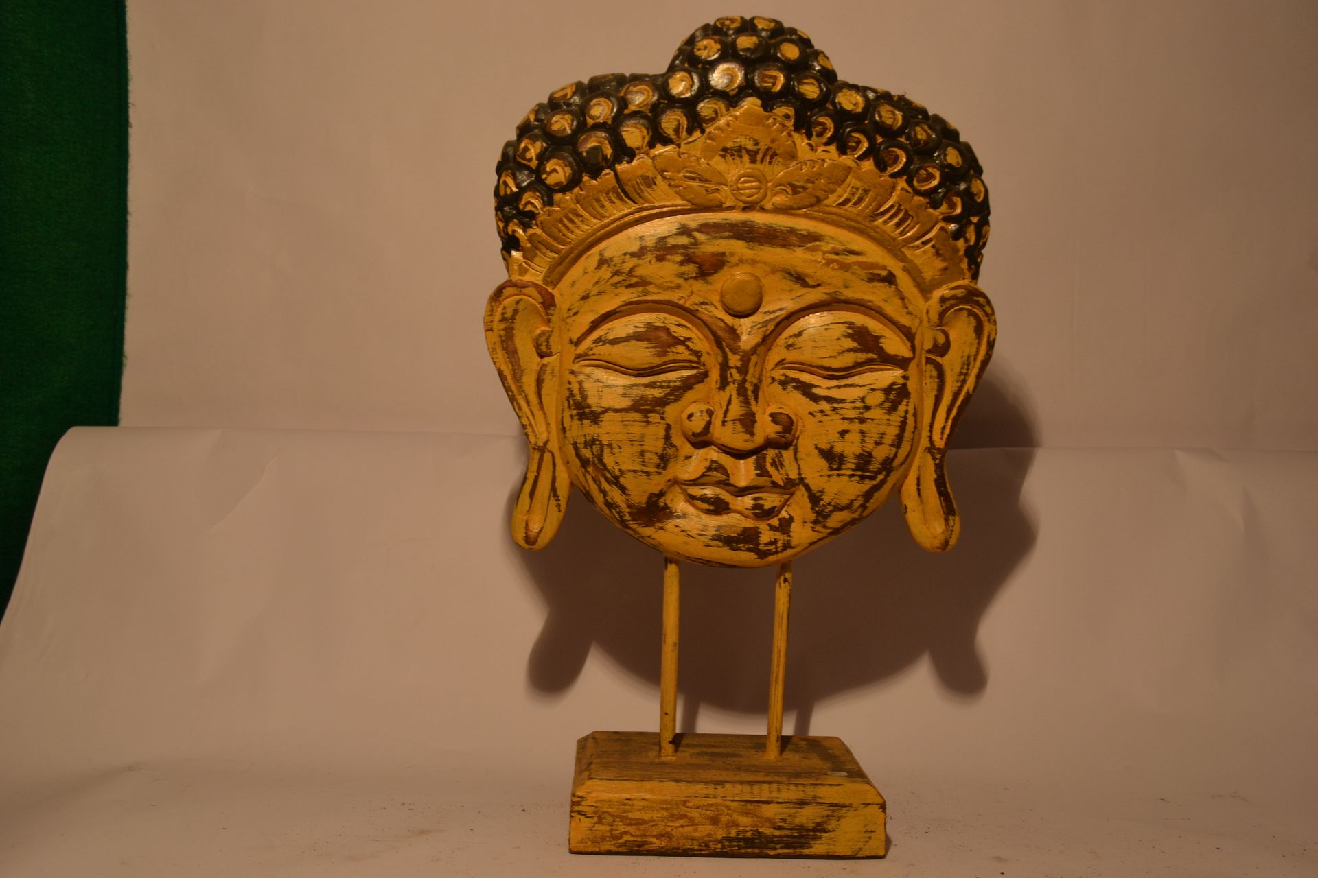 Null Buddha-Kopf auf einem Sockel.

Exotisches Holz mit gelb-schwarzer und goldf&hellip;