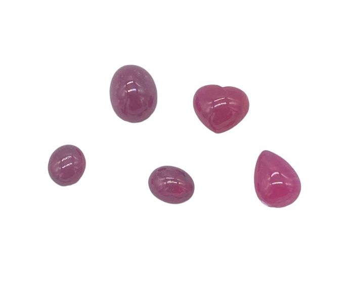Null Five ruby cabochons on paper, oval, heart and drop, total approx. 9 cts