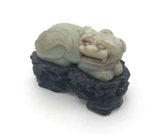 Null 中国--钱龙时期(1736-1795)
一件青瓷玉石（软玉）卧狮像，头转向右边。长8.5厘米。紫檀底座（多处粘连）。