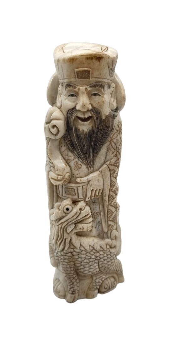 Null 中国 - 20世纪
骨质雕像，站立的仙人手持如意宝杖，脚下是一只麒麟。高13.5厘米。