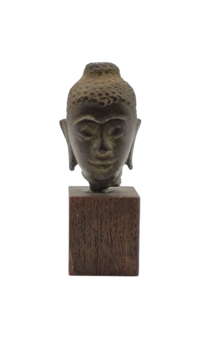 Null 泰国 - 16/17世纪
棕色铜质小佛头，半闭着眼睛，头饰细微卷曲，头顶有乌斯提萨。高4厘米
