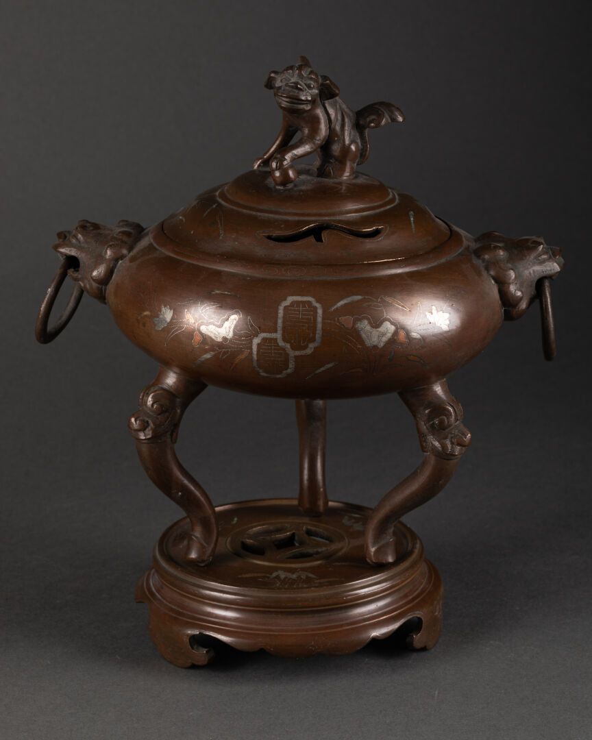 VIETNAM - Vers 1900 三足鼎立的烧蜡烛器及其底座。用植物做装饰。

盖子的顶部是一只Fô狗。

棕色铜锈镀镍青铜

H.21 cm - L. &hellip;