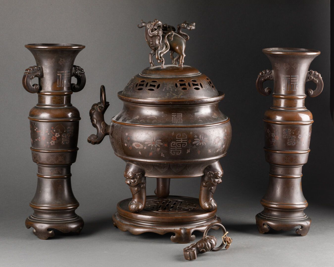 VIETNAM - XIXème siècle 由一个炉子和一对花瓶组成的棒子，上面装饰着表意文字和花。

纹饰为麒麟，手柄为神奇的鸟，底座为大象头。

青铜镀&hellip;