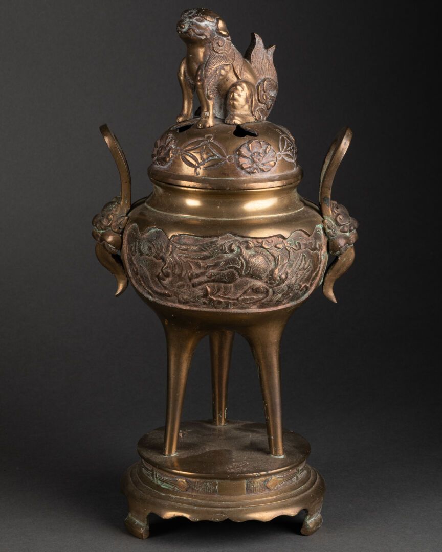 CHINE - Vers 1900 三足鼎立的烛台连接在底座上，饰有龙纹和麒麟纹的储备。

盖子上有一只福狗。

抛光的青铜

H.30厘米