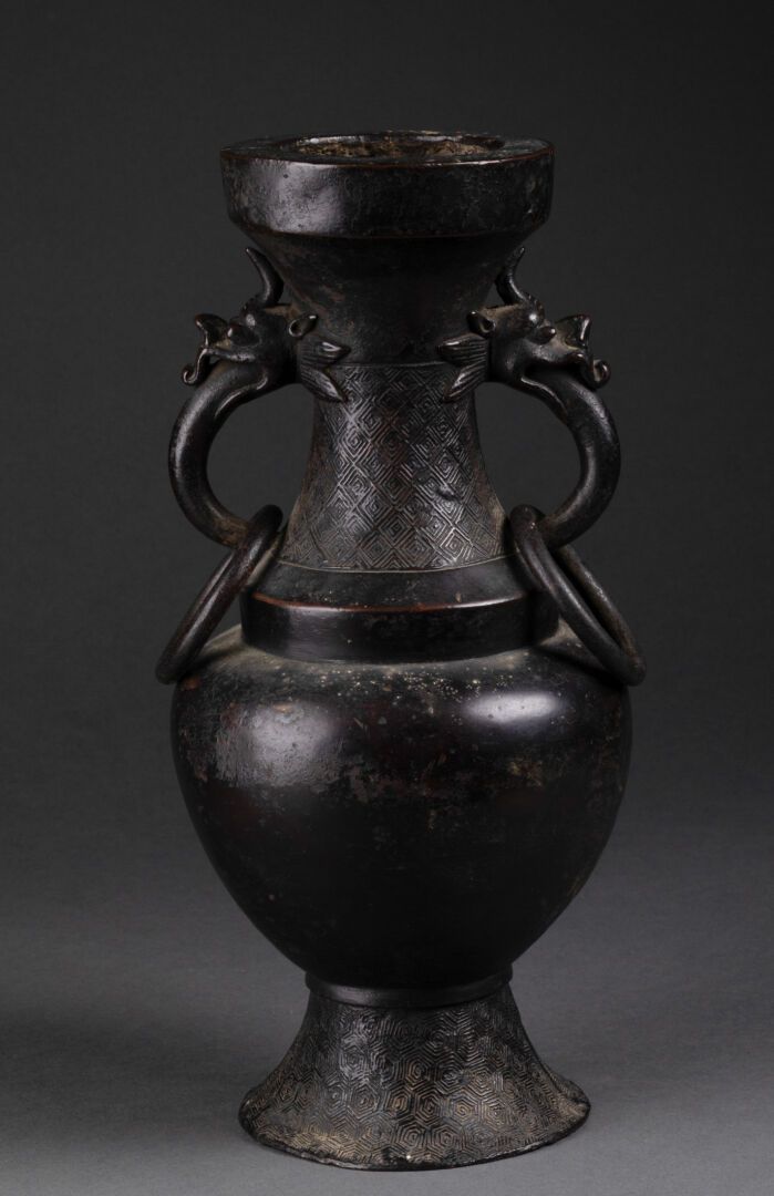 CHINE - Dynastie MING (1368-1644) 台座上的巴斯特花瓶

颈部装饰有雷文图案的底面

龙头形状的把手拿着环形的把手

古铜色

&hellip;