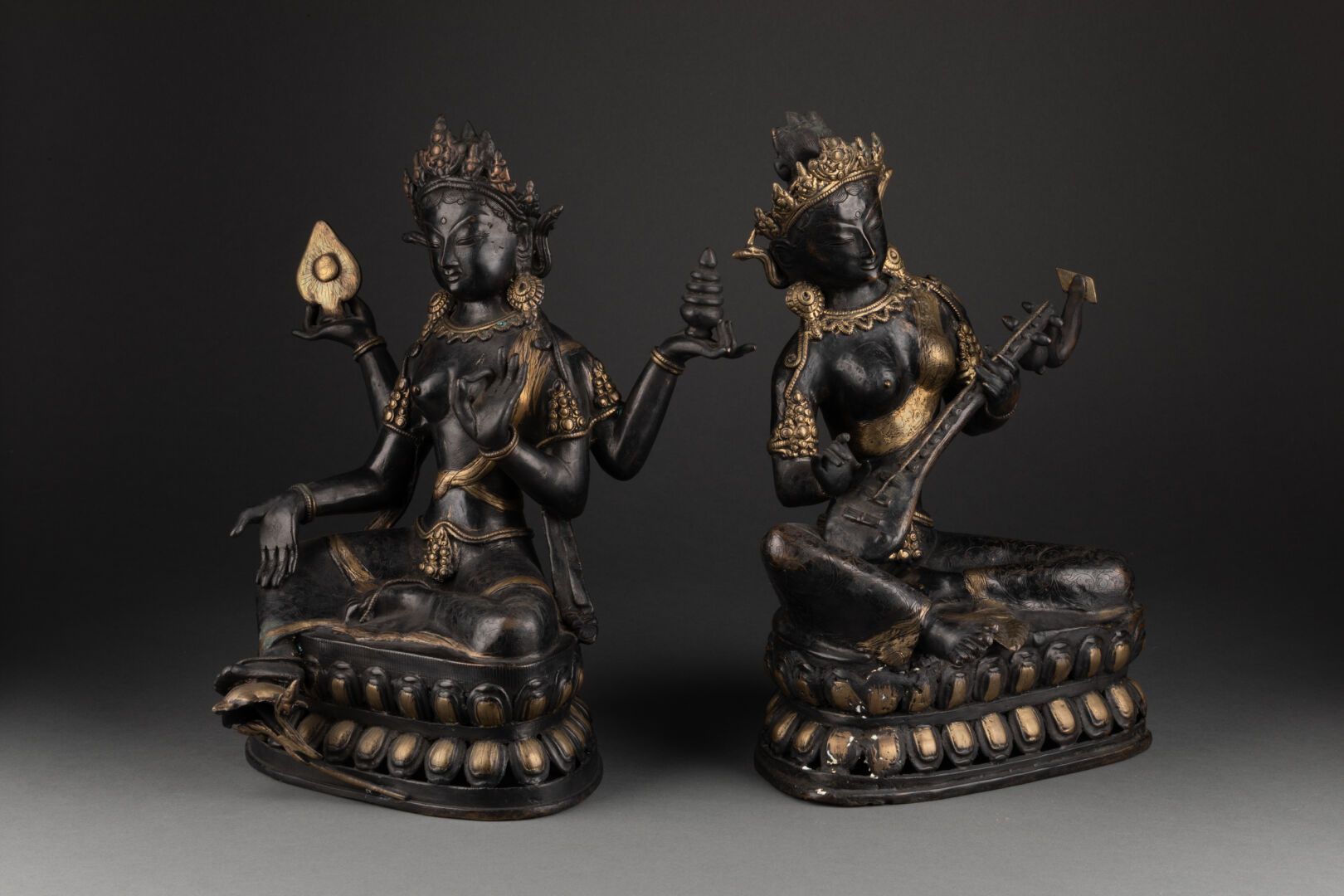 TIBET - XIXE SIÈCLE 两位印度教的神灵坐在一朵双莲上，一位有四只手臂，另一位是音乐家

青铜，有两种青铜色

H.31 cm - W. 20 &hellip;