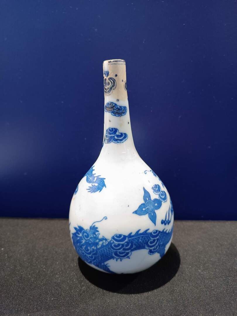 VIETNAM - XXe siècle 龙在云端的花瓶瓶身 
瓷器和蓝印花布装饰 
H.17厘米 
修复后的颈部