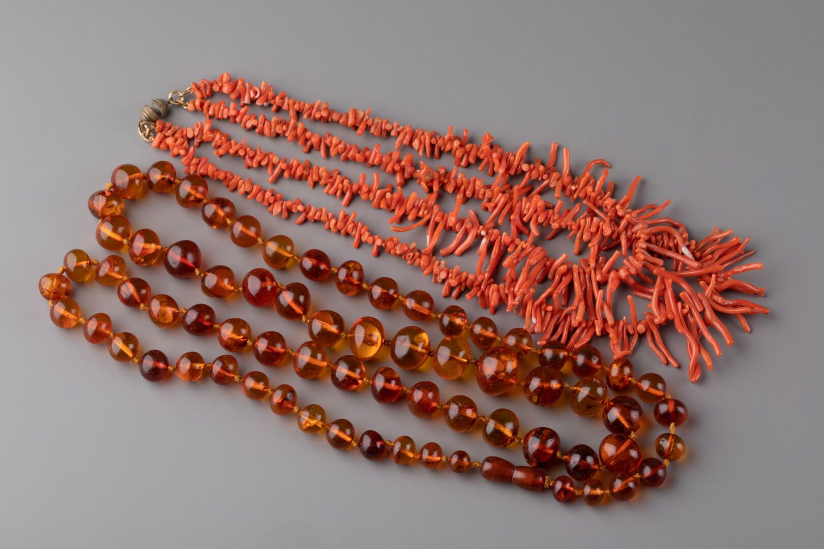 Null 由两个项链组成，一个由珊瑚枝制成，另一个有琥珀色的珠子。