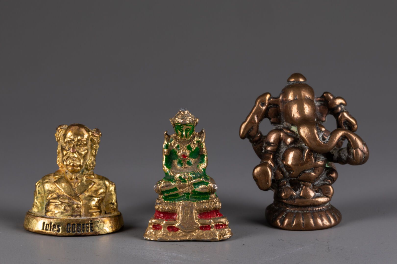 [SOUVENIRS DE VOYAGE] 拍品包括两个亚洲神像 
包括一个朱尔-古菲的微型半身像 
青铜和金属合金 
最大高度为5厘米