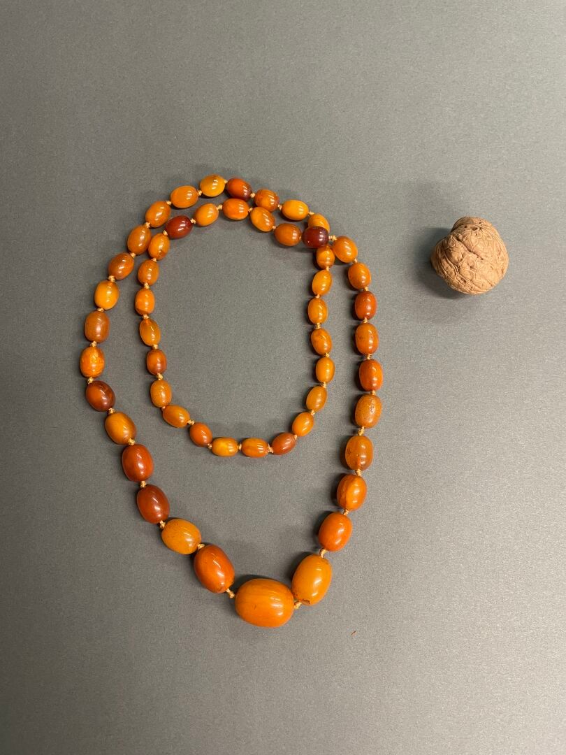 CHINE Un collier composé de 53 perles d'ambre 
L. Collier: 45 cm
Diam. Perles: d&hellip;