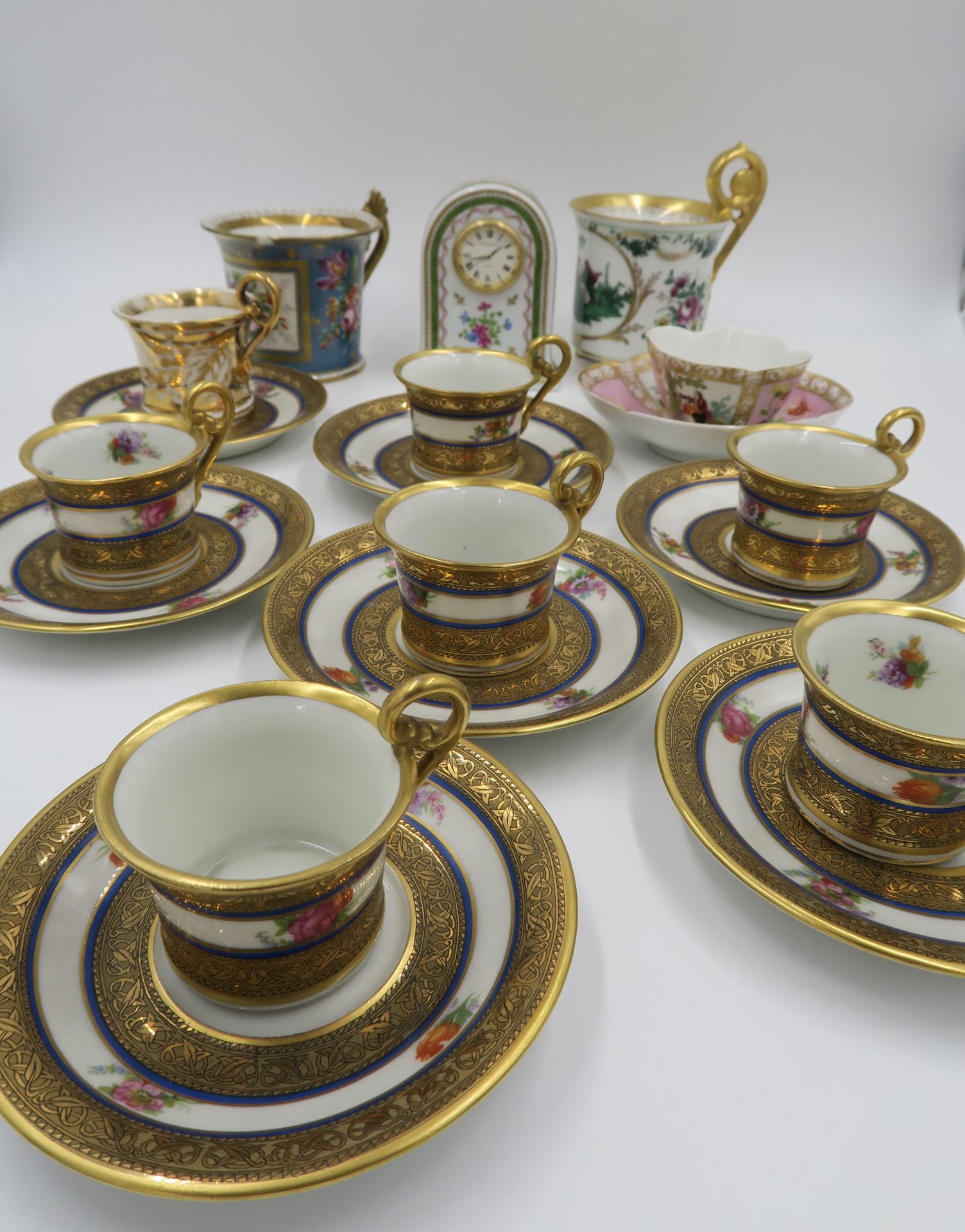 Null 瓷器摩卡套装，20世纪，有多色装饰和金色卷轴，一个另一型号的杯和碟，两个损坏的升杯，一个多叶形的杯子

附有一个哈维兰石英钟