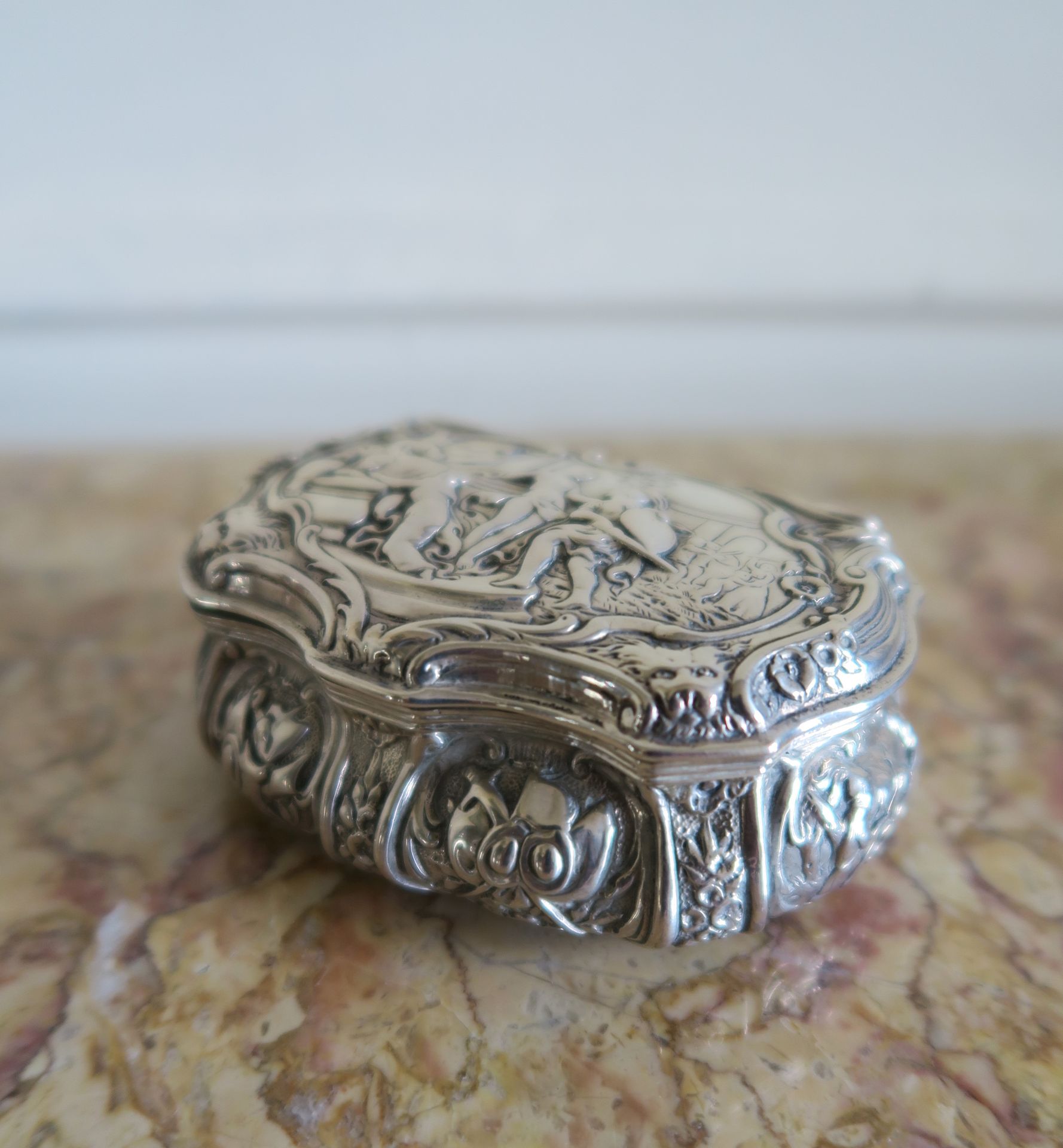 Null 一个外国银质鼻烟盒，盖子上装饰有一个古董场景，以及罗盖尔、卡图尔、刺绣

长8.5厘米。PB。80 g