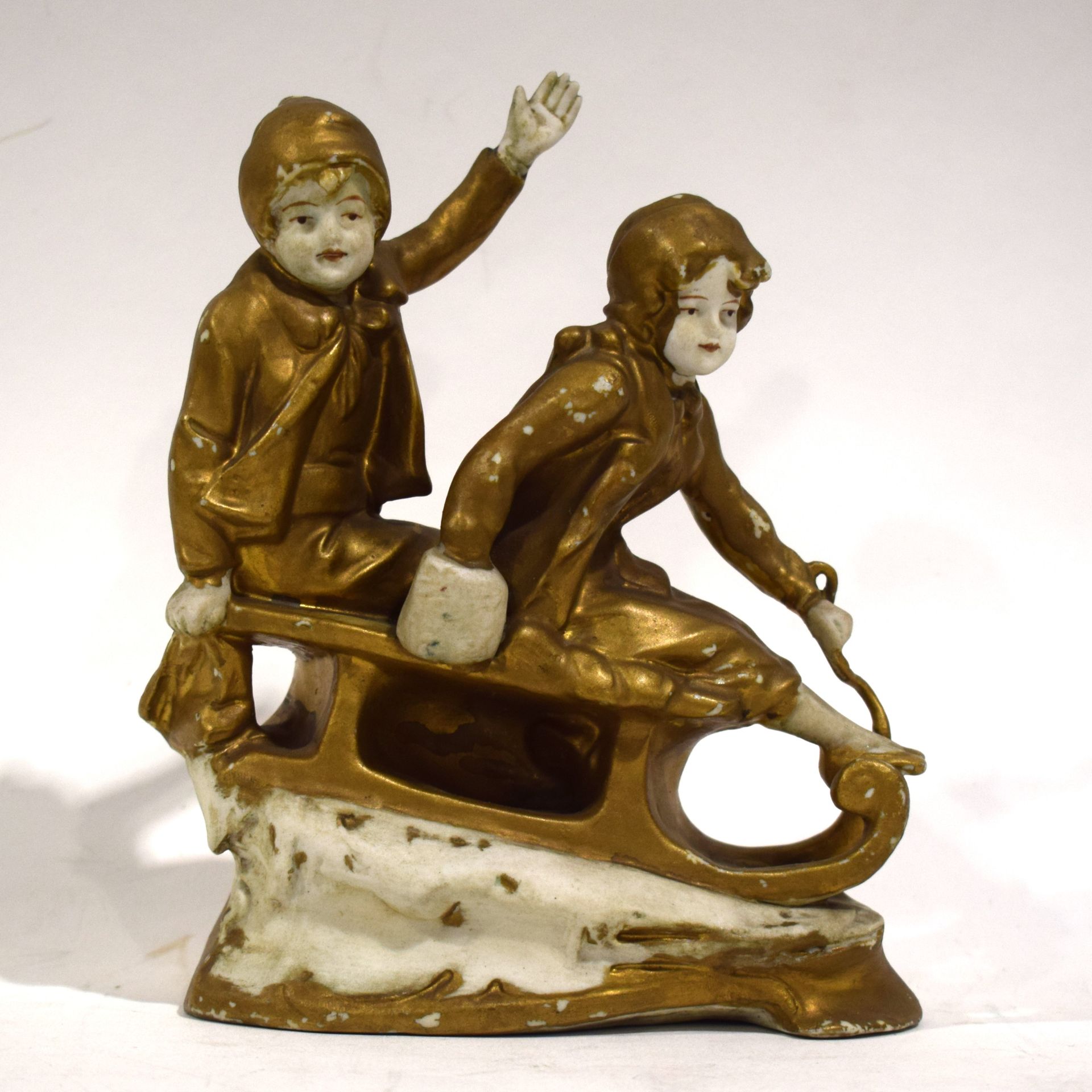 Null (PORCELANA) Grupo de bisque de 2 niños en un trineo, figuras doradas (falta&hellip;