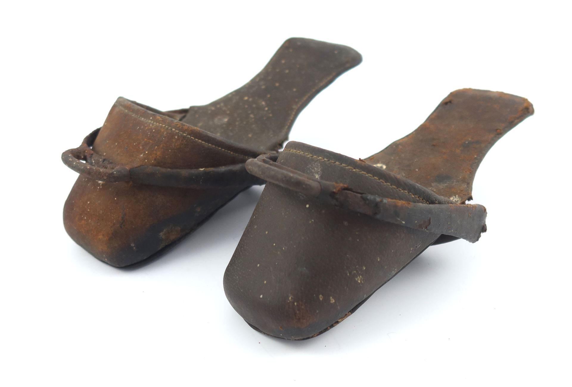 Null 一对儿童骑马拖鞋的马镫，手工缝制的皮革和金属，可能是18或19世纪初。类似的例子见法国伊泽尔河畔罗曼斯的鞋子博物馆。