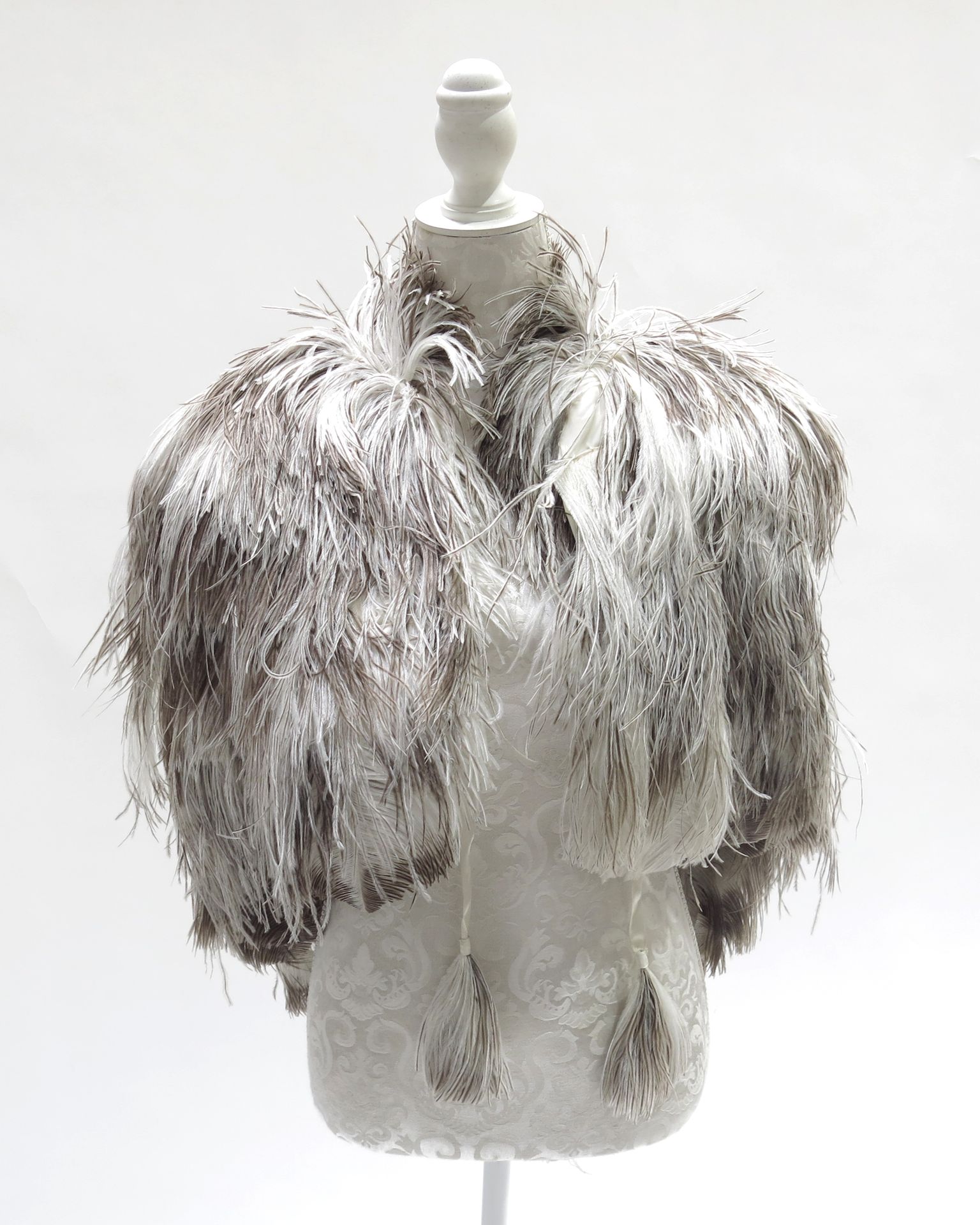 Null 一件优质的1920/30年代羽毛肩披风，双色，奶油色/棕色，来自雌性鸵鸟，奶油色内衬，形状为背部深陷，前面的领带用羽毛完成，脖子到后面的下摆大约23英&hellip;