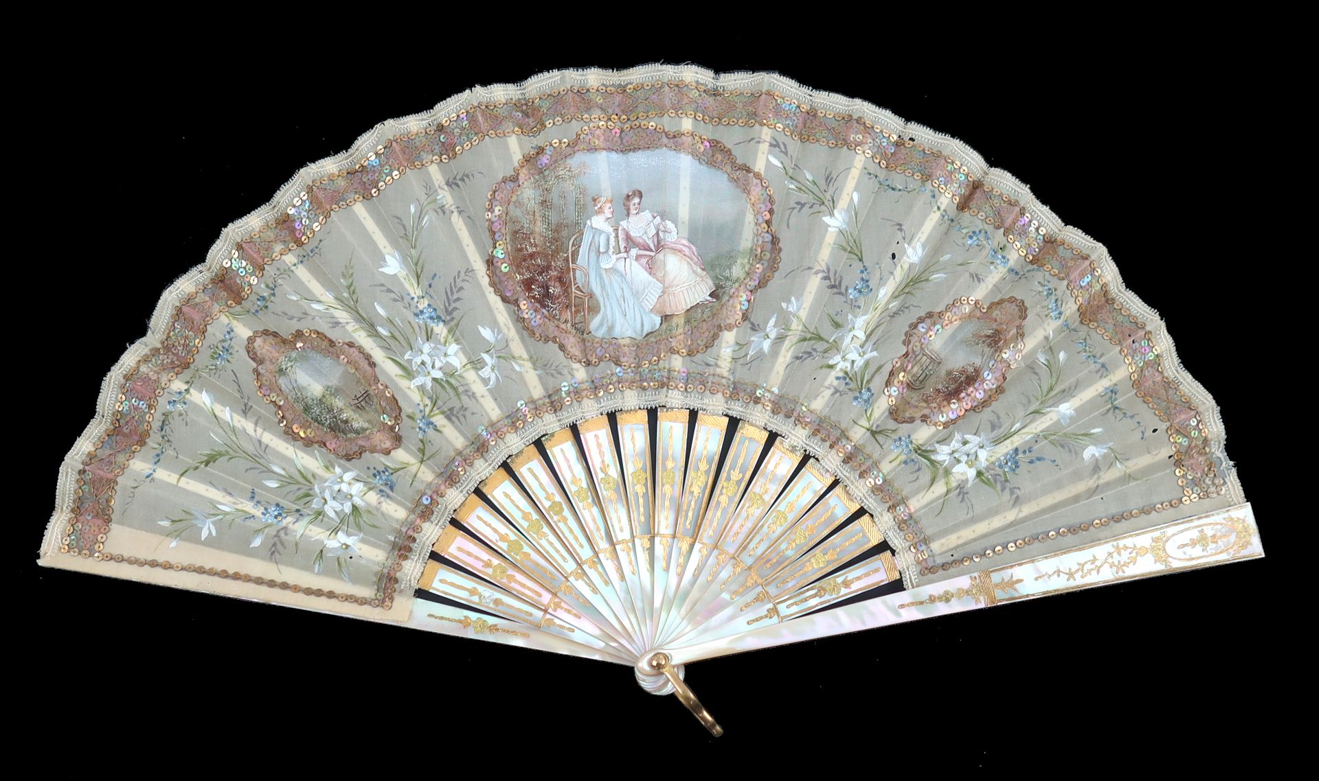 Null 一把非常有装饰性的扇子，约1900-1910年，闪亮的淡粉色珍珠母镀金，奶油色的纱质叶子装在à l'Anglaise上，保留物上精致地画着蓝色和白色的&hellip;