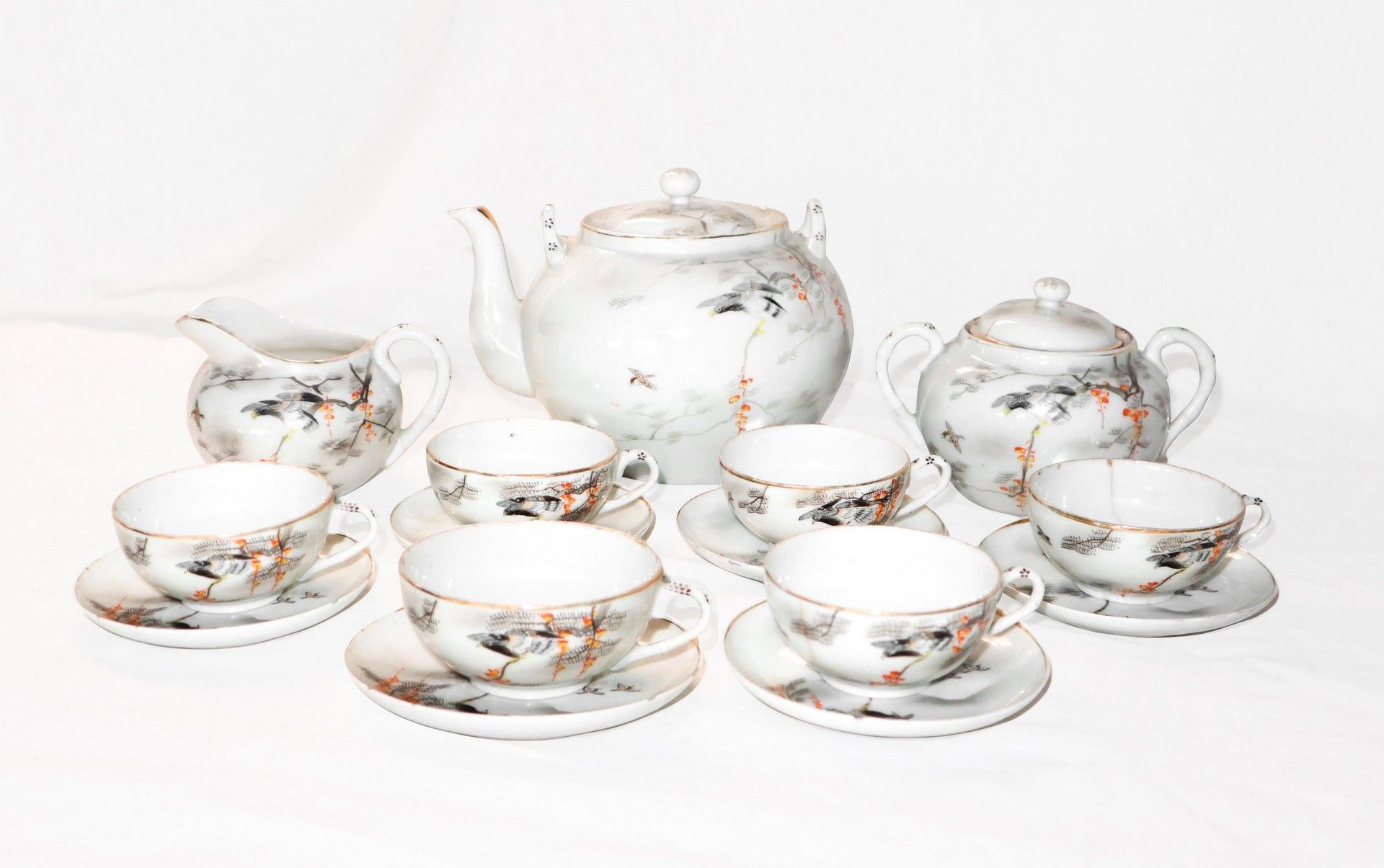 Null 中国瓷器茶具包括12号杯和茶托，牛奶壶和糖碗。由12个杯子和茶托，牛奶壶和糖碗组成。有橙色和金色的装饰，有鸟的装饰。