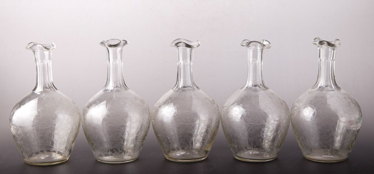 Cinco garrafas en forma de botella, de vidrio incoloro, …