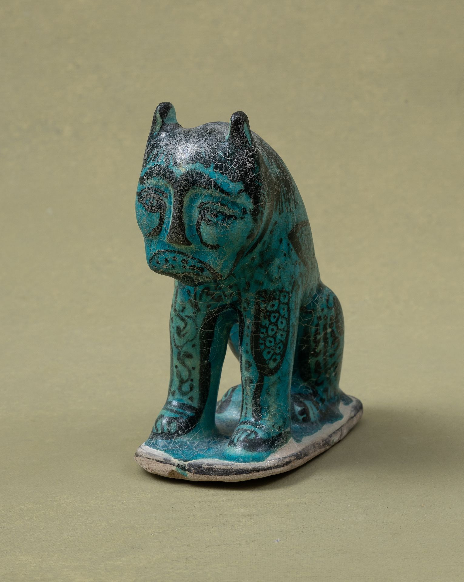 FIGURINE DE LION ASSIS 
伊朗，卡尚，塞尔柱艺术，约1200年









模制硅质陶瓷，在绿松石的釉面下涂以黑色，器身饰以卷轴和鳞&hellip;