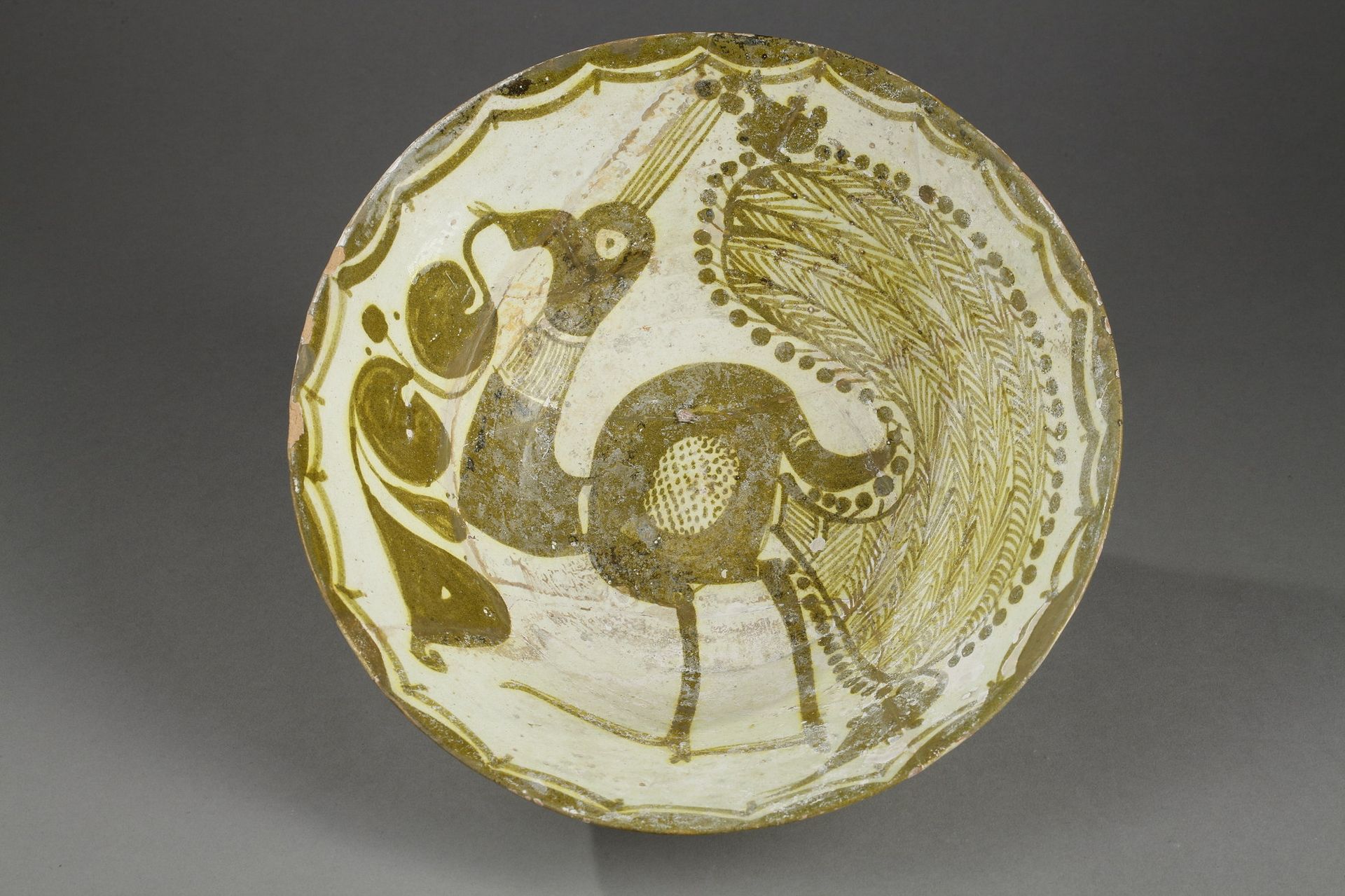 COUPE AU PAON 
东伊朗，NISHAPOUR，10世纪









一个截顶的圆锥型泥碗，在米色滑面和透明釉面上涂有 "假色"，装饰着一只孔雀&hellip;