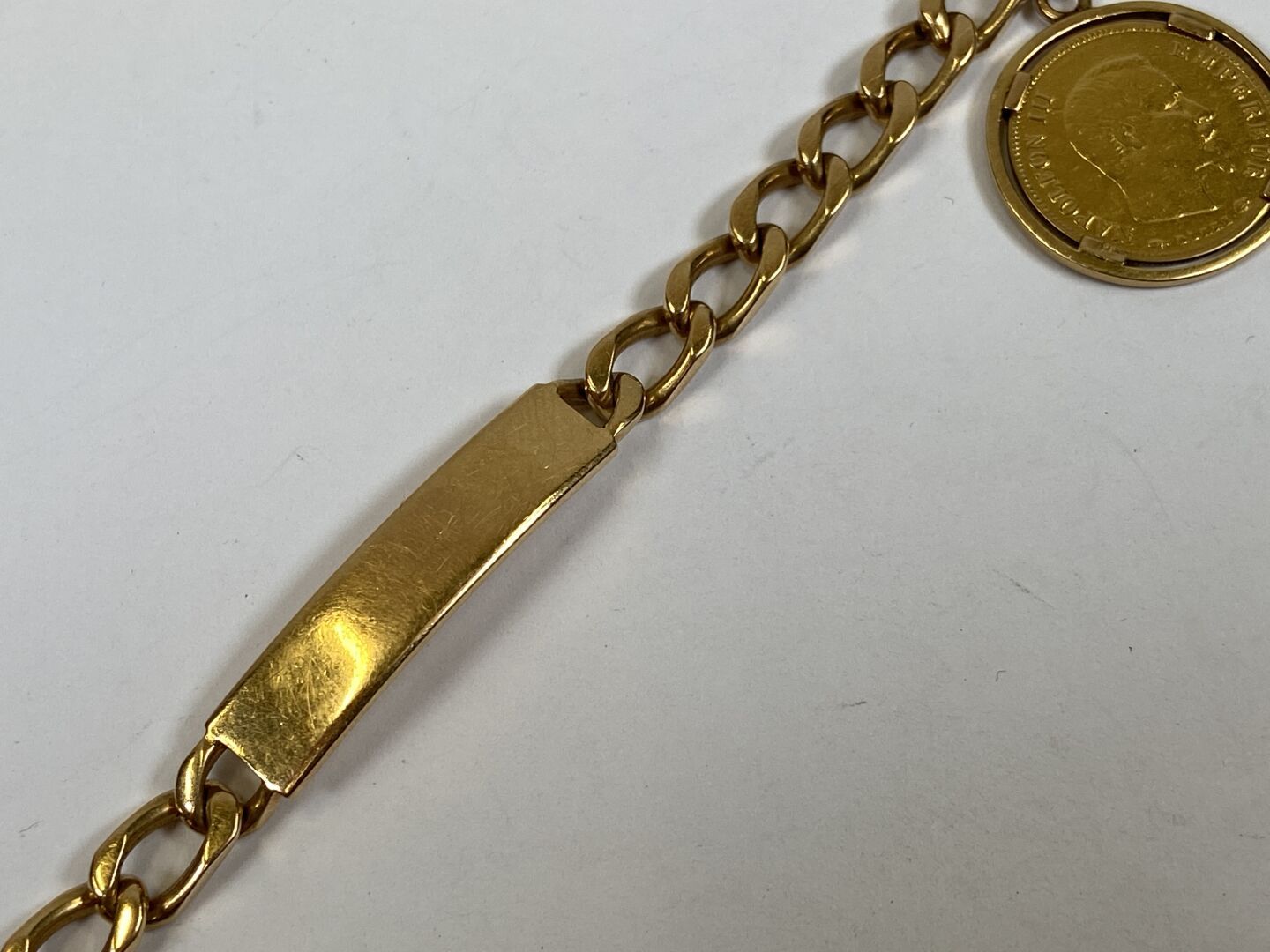 Null 18K黄金手镯或手链，吊坠中装有一枚10法郎金币拿破仑三世光头，1856年A。

重量：26.4克。

L. 17,5 cm.