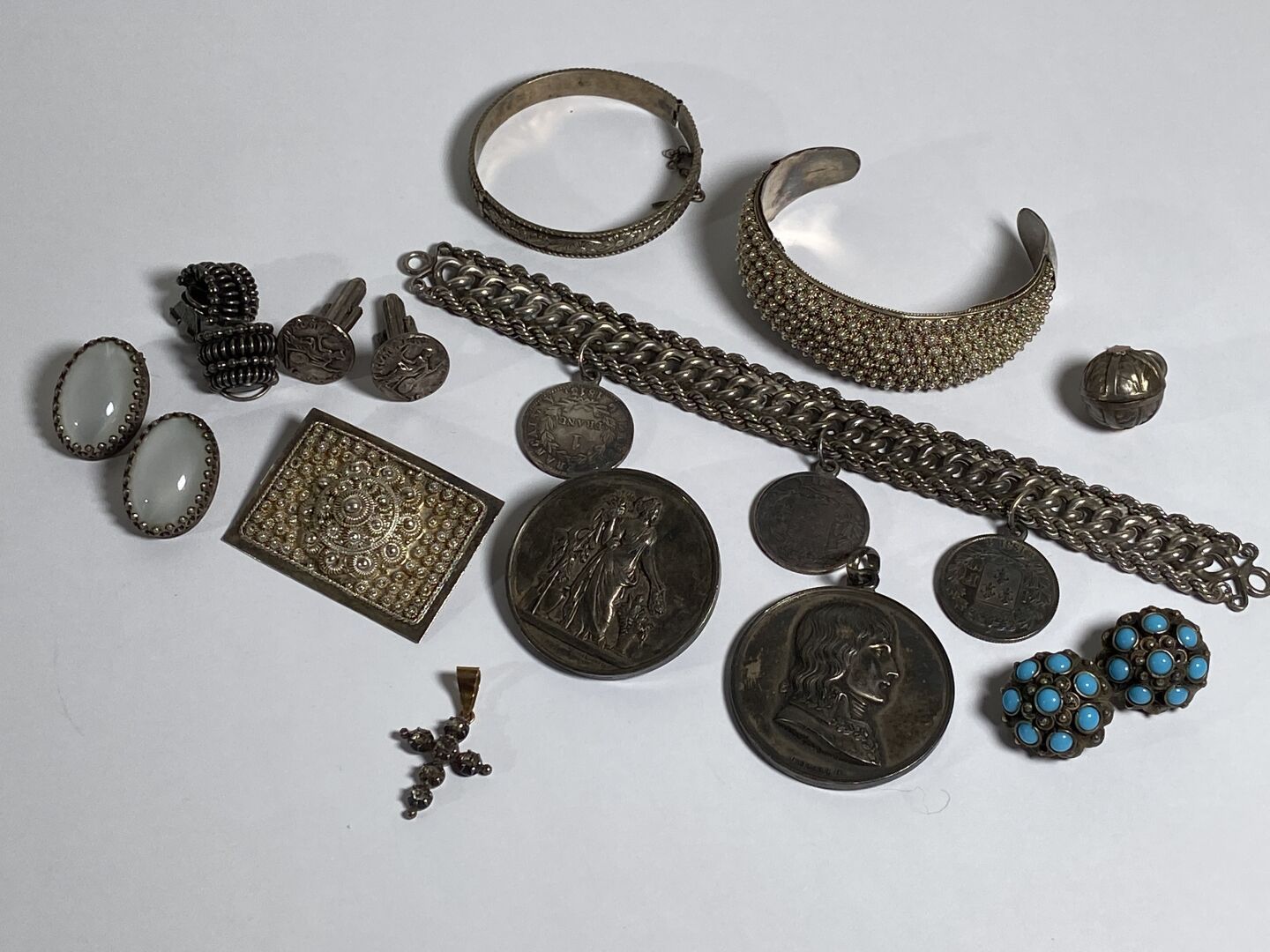 Null 一套银质首饰或服装首饰，包括 :



- 一个带有三枚19世纪银币的手镯。重量：35.7克。L. 18 cm.

- 一枚银质圆形葡萄酒奖牌，作为胸&hellip;