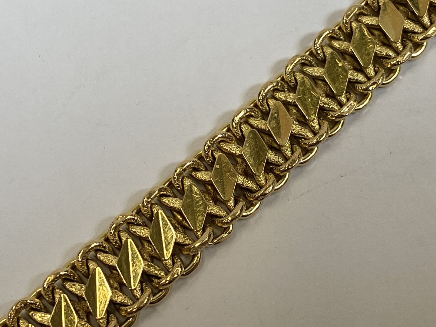 Null Bracelet en or jaune 18K à malle aplatie rythmée de motifs losangiques.

Po&hellip;