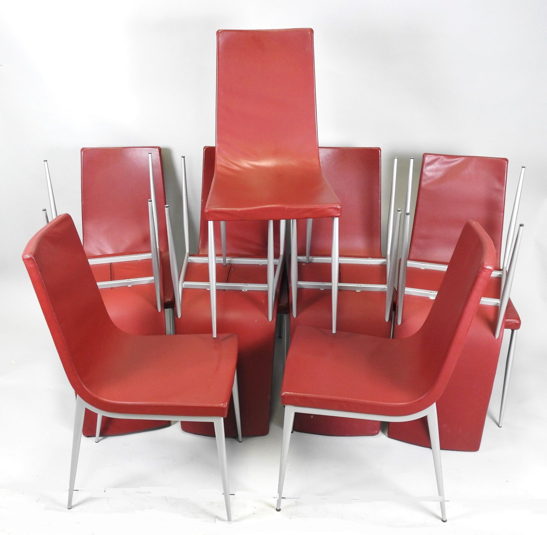 Null Suite aus zwölf Stühlen aus rotem Skai und grauem Metall.
Arbeit aus den 90&hellip;
