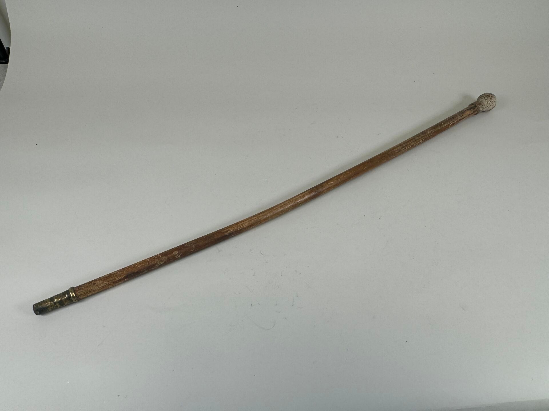 Null 木制手杖，带编织绳钮和金属黄铜杖尖。
长 93.5 厘米。
(略有扭曲）。