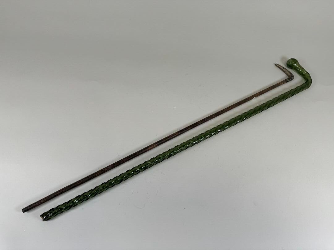 Null 拍品 ：
- 木制手杖，鞍座可能是银制的，有昆虫装饰。
长：89 厘米。
- 绿色玻璃手杖，带扭曲手柄。
(末端断裂）。