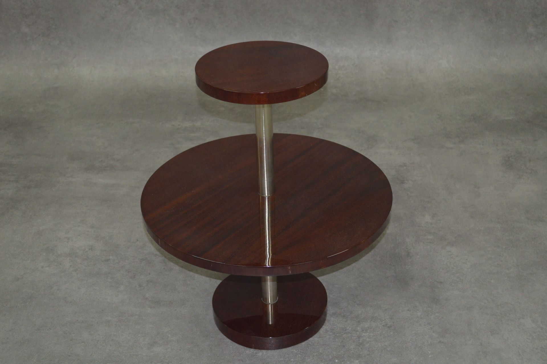 Guéridon Art Déco 
基
座式桌子。金属的中央脚。两个盘子。 木饰面。
1930-40年代。上层托盘的尺寸：约29厘米。中央托盘的尺寸：约60厘&hellip;