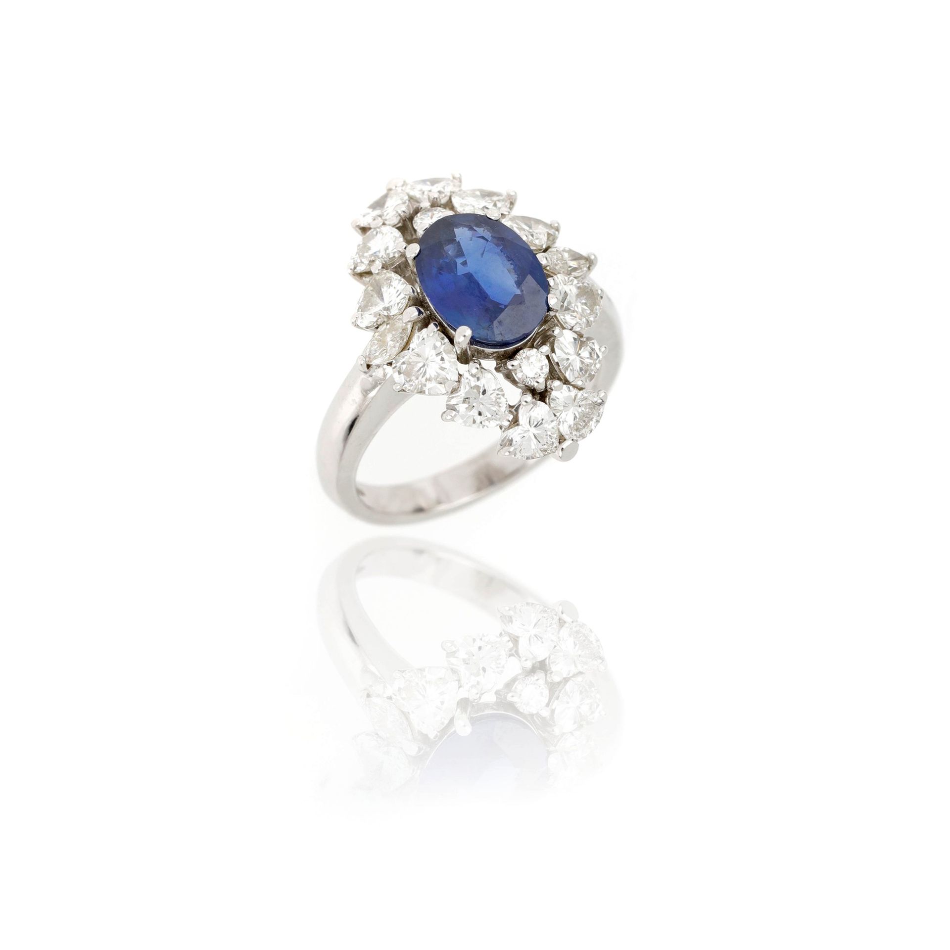 Null 18K白金戒指，镶有一颗椭圆形蓝宝石，重约1.75克拉，周围有圆形明亮式切割和心形切割钻石，共重约2.15克拉，尺寸为11/51，重7.11克。

1&hellip;
