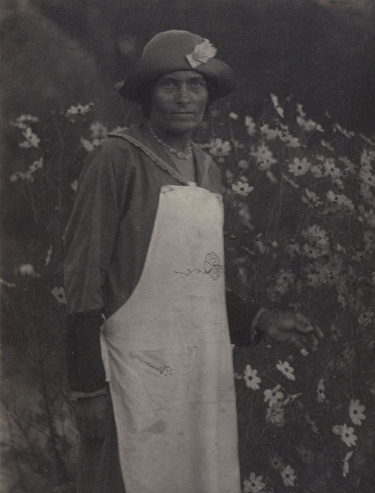 DORIS ULMANN (1882–1934) 
多丽丝-乌尔曼 (1882-1934)

穿围裙的女人与花园里的波斯菊，1932-34年

图片尺寸：20,&hellip;