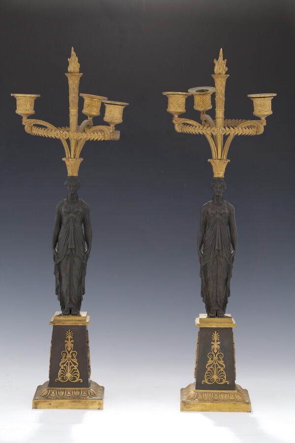 Null 一对带3个灯的烛台

帝国时期

古铜色和鎏金铜色

表现一个女人披着古董式的衣服，拿着一束花（canéphore）。

鞘中的底座上涂有棕榈花纹和镂&hellip;