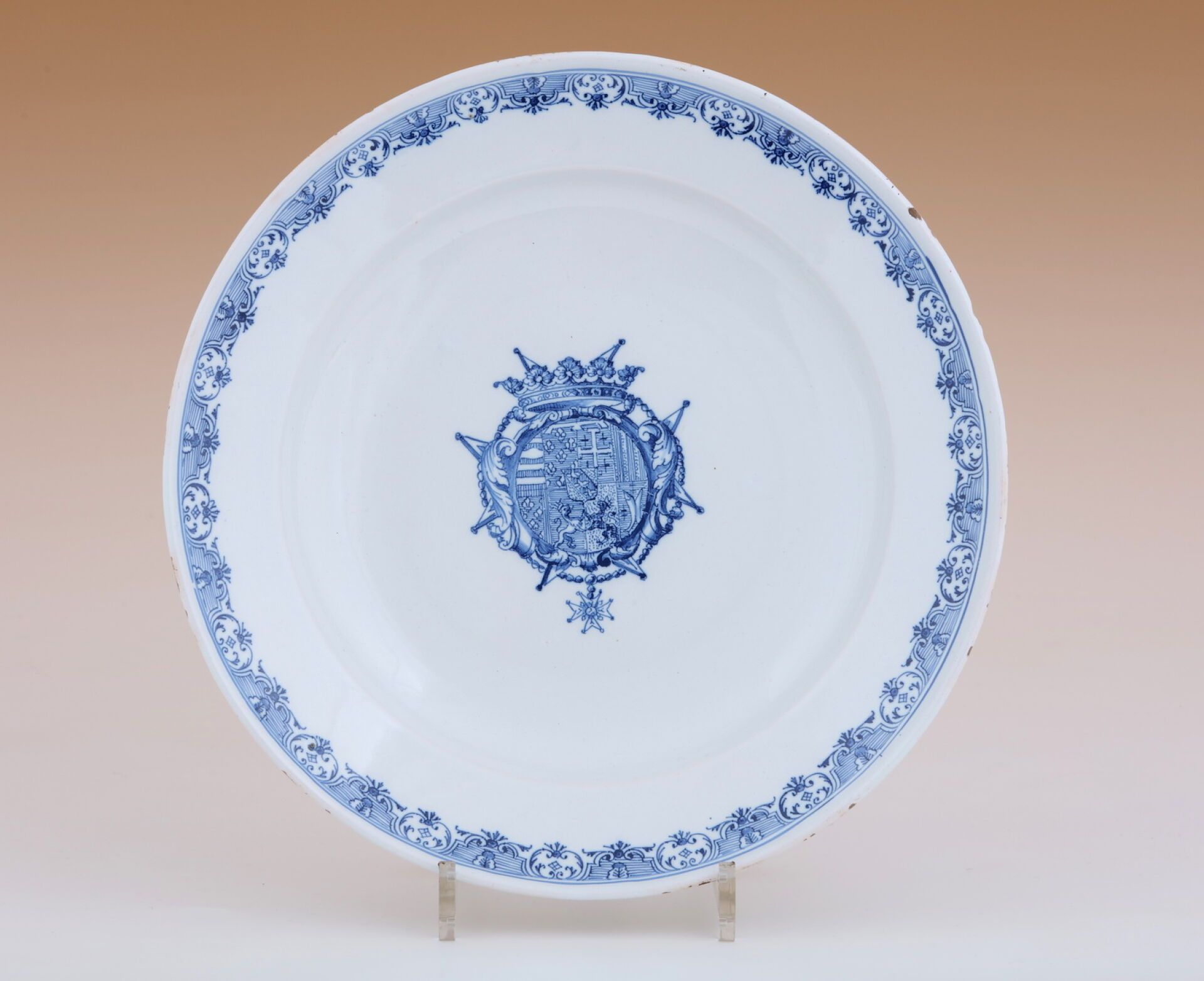 Null 大圆板
钵，18 世纪
釉陶 
中央为蓝色单色纹饰，饰有纹章，边缘有幔帐
长 31.5 厘米
(边缘有小的珐琅碎片）