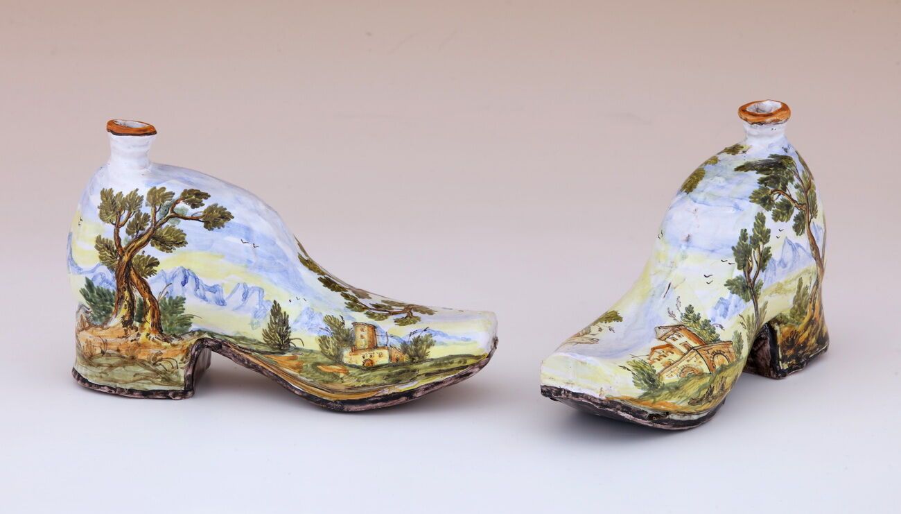 Null 一对鞋形热水瓶
意大利，卡斯泰利工厂 - 18 世纪
马乔利卡材质，多色风景装饰
H.12.5 厘米 - 20 厘米