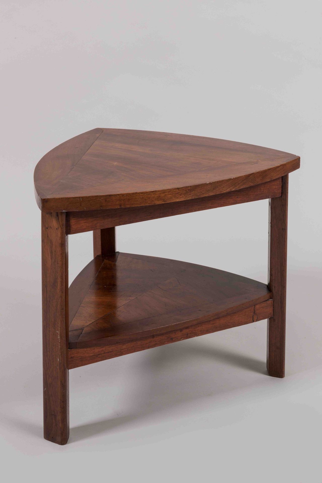 Null 三角形胡桃木饰面的VOLANTE桌。三脚架底座由一个间隔架连接。

装饰艺术风格。

高度：43厘米。宽度：43厘米。深度：46厘米。(小事故)。
