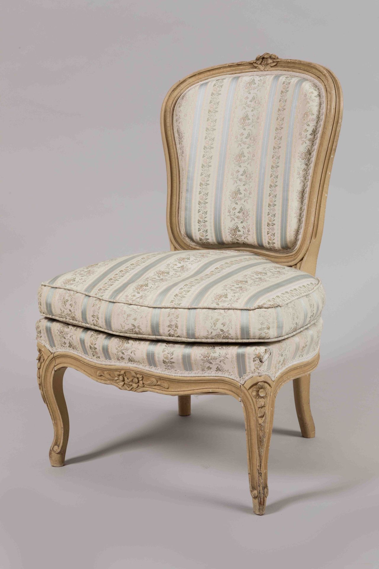 Null 一把模制的、雕刻的和重新上漆的木制敞篷椅，上面装饰着叶子花朵，靠在四个拱形的腿上。

路易十五风格。

奶油色软垫上有蓝色条纹和多色花。

高度：80&hellip;