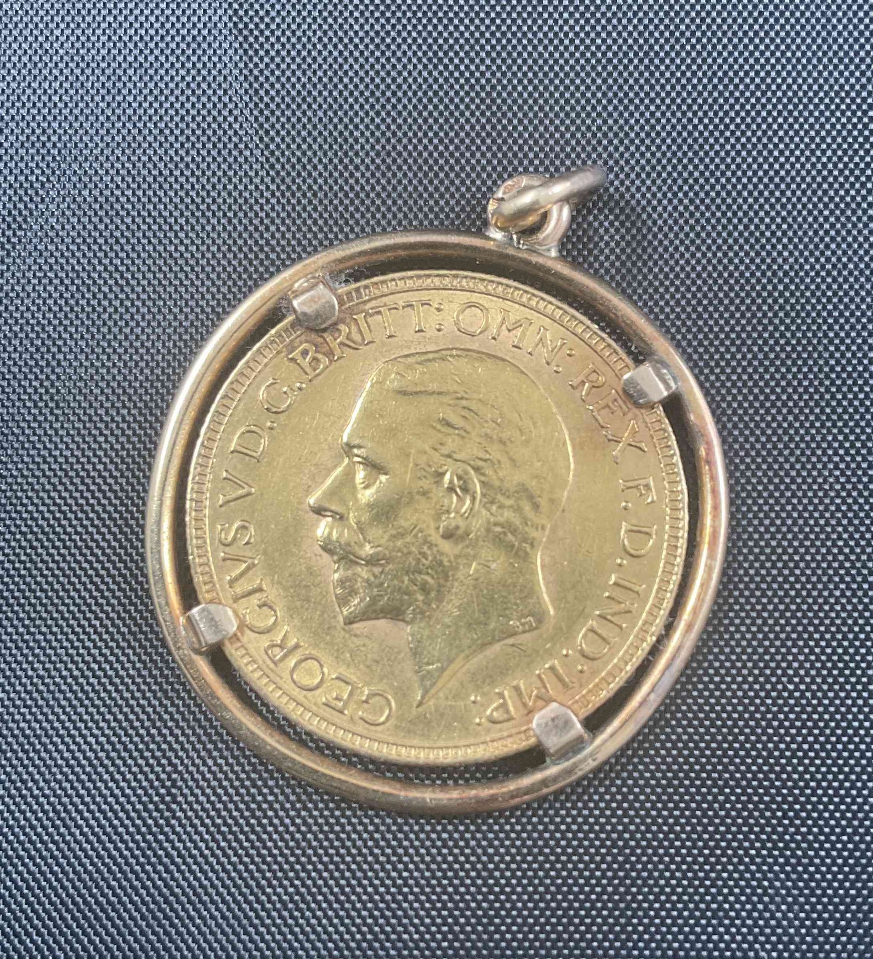 Null 
黄金吊坠，75万分之一，手持带有国王乔治五世轮廓的金质主权，1930年。

直径2,6厘米。重量：10.44克。