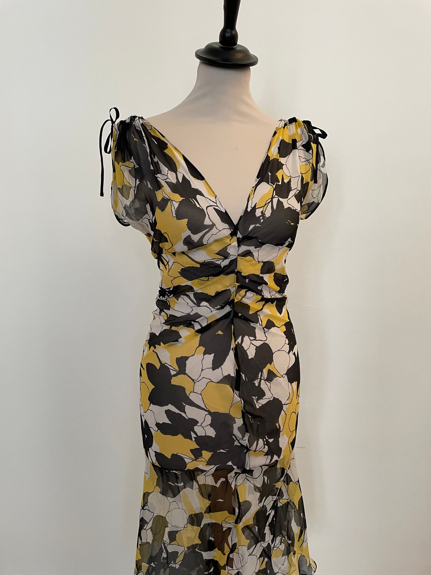 Null DIANE VON FURSTERBERG

黄色、黑色和白色花朵图案的轻量级丝绸连衣裙。

T.2

衣服底部缺损，线头拉断。