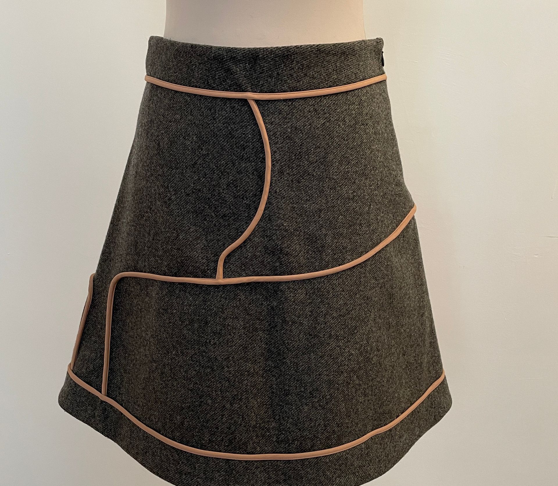 Null 丸子

灰色羊毛的梯形裙，有旧粉色的辫子。

T.38

腰部宽度35厘米，腰部至衣服底部的高度48厘米，衣服底部的宽度65厘米