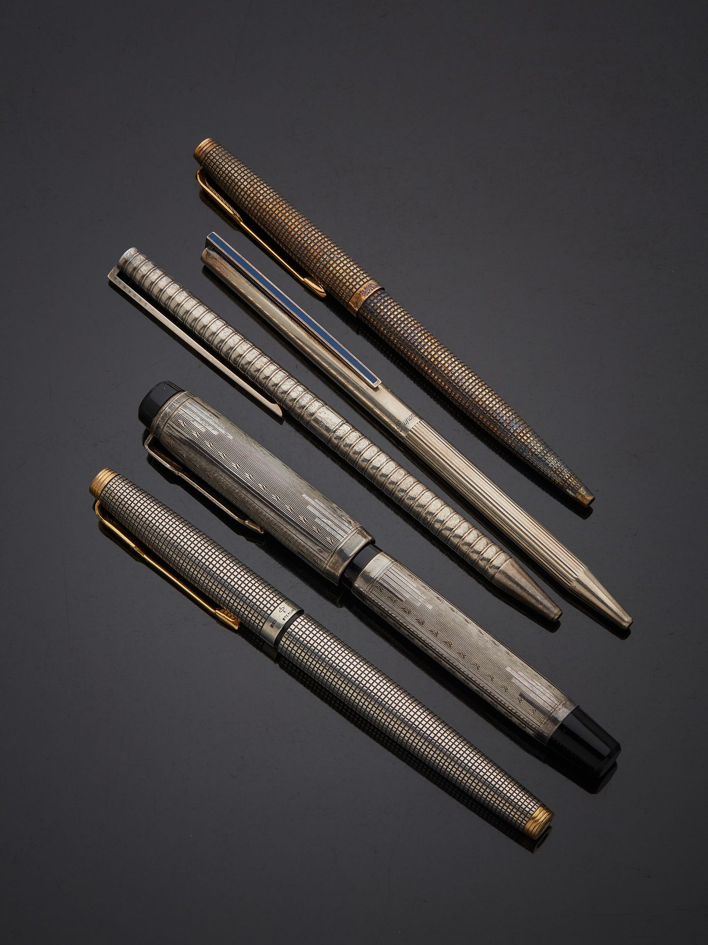 Null 拍品包括
两支银制钢笔和三支银制圆珠笔，包括派克（Parker）、ST 杜邦（ST Dupont）和各种银制圆珠笔：派克、ST 杜邦和各种。
已磨损。&hellip;
