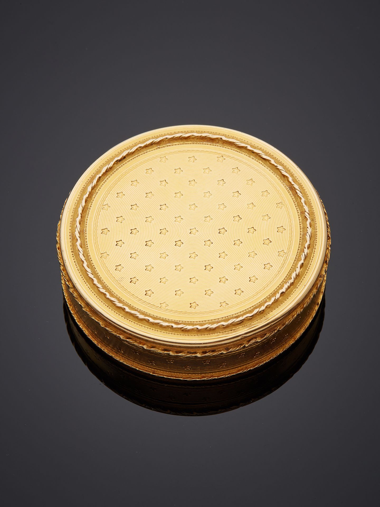 Null Boîte en or jaune 18K 750‰, de forme ronde, guillochée et cintrée de cordes&hellip;