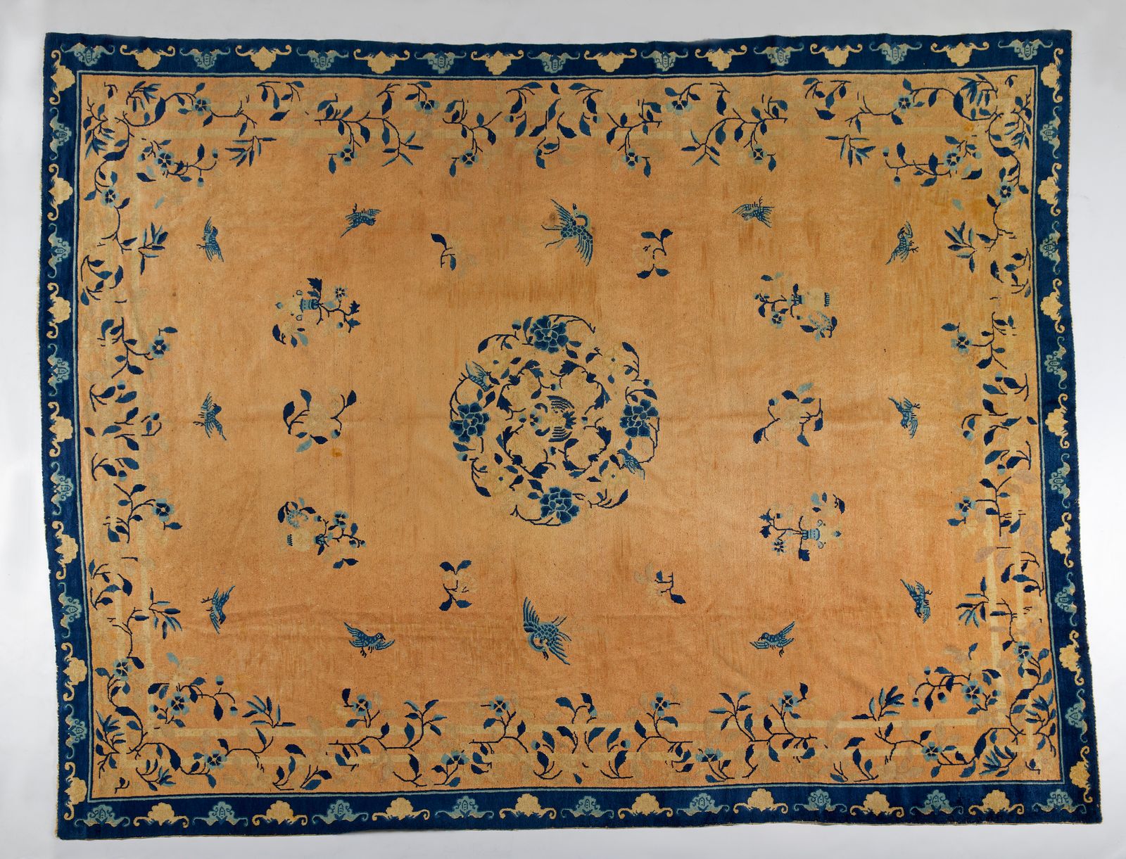 Chinese Art A large Beijing rug 中国艺术。一个大型的北京地毯，中国，19世纪末。一个大型的米色地面地毯，装饰着蓝色花朵中的鸟儿，&hellip;