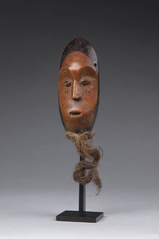 Null Kidumu mask with its raffia beard. The concave face is double scarified on &hellip;
