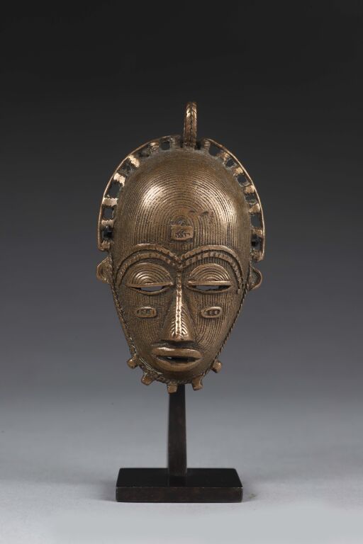 Null Pendant representing a mask entirely covered with fine parallel lines and h&hellip;