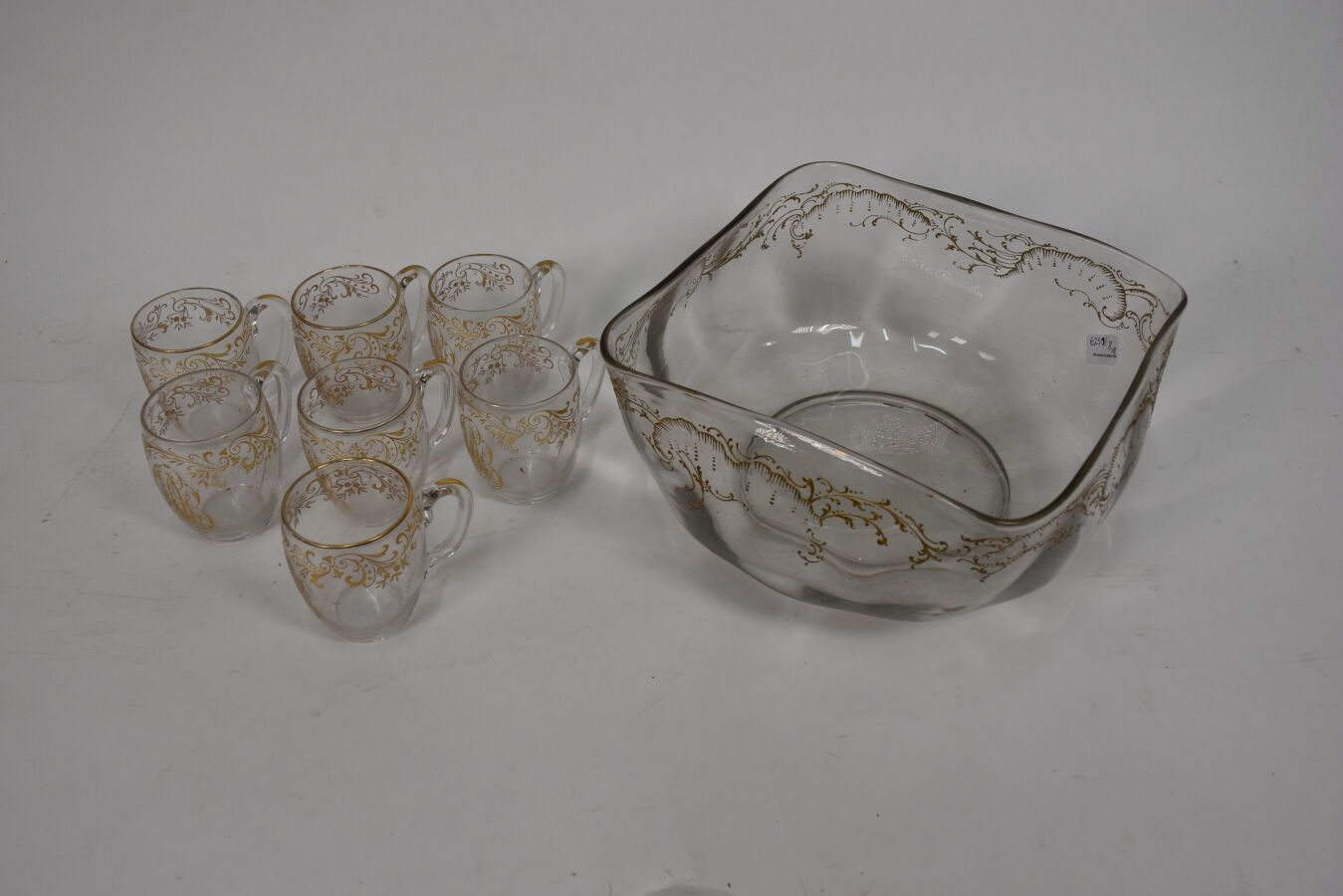 Null 金色卷轴和字母图案装饰的玻璃桑格利亚套装

包括七个杯子和一个碗

(事故)