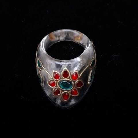 Null 一枚岩石水晶弓箭手戒指上镶嵌着凸圆形宝石，描绘着一朵有八片花瓣和含苞待放的花茎，由金线连接和环绕，采用昆丹技术。
印度，莫卧儿风格
L. 5 cm